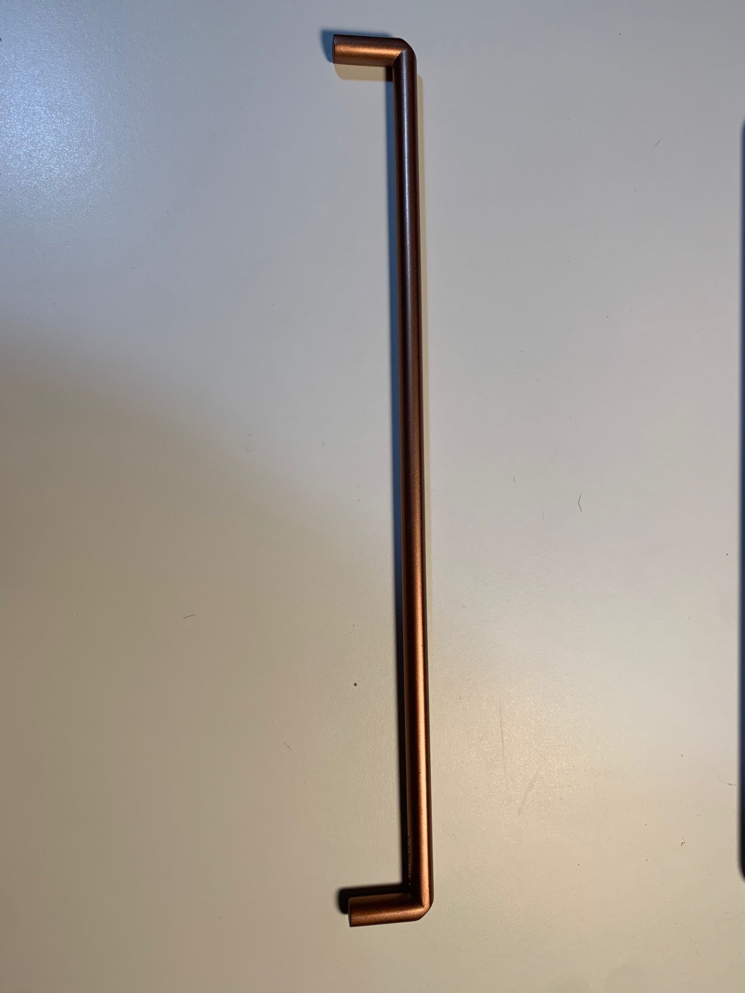 Poignée de meuble en cuivre utilisée comme référence pour les tests dans RoomLab